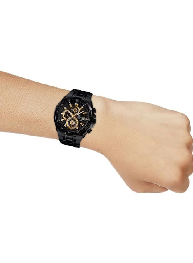Black wristwatch with gold accents on a wrist against a white background